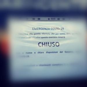 un cartello all'ingresso di un bar durante il lockdown